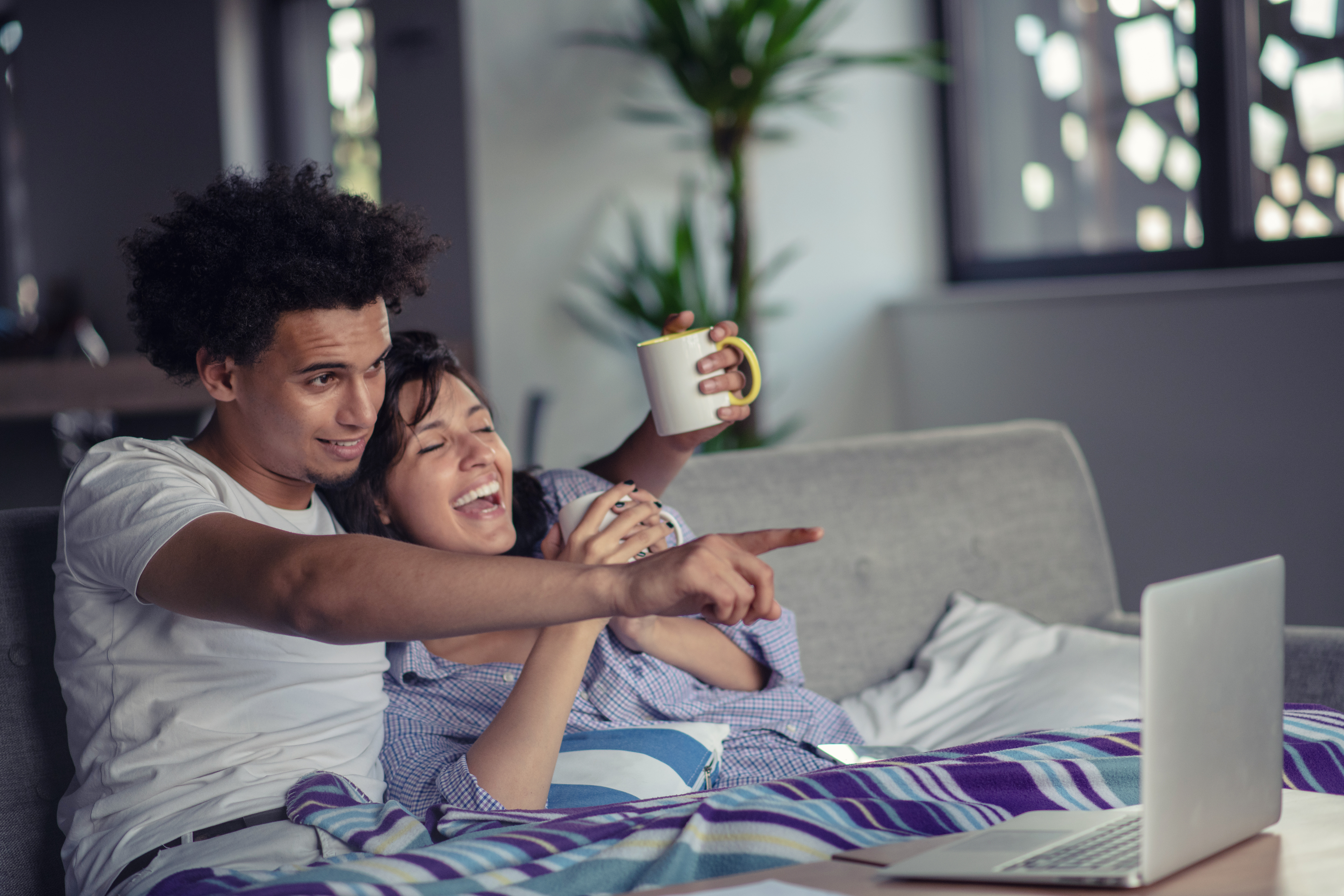 Young couple watching a movie on their laptop