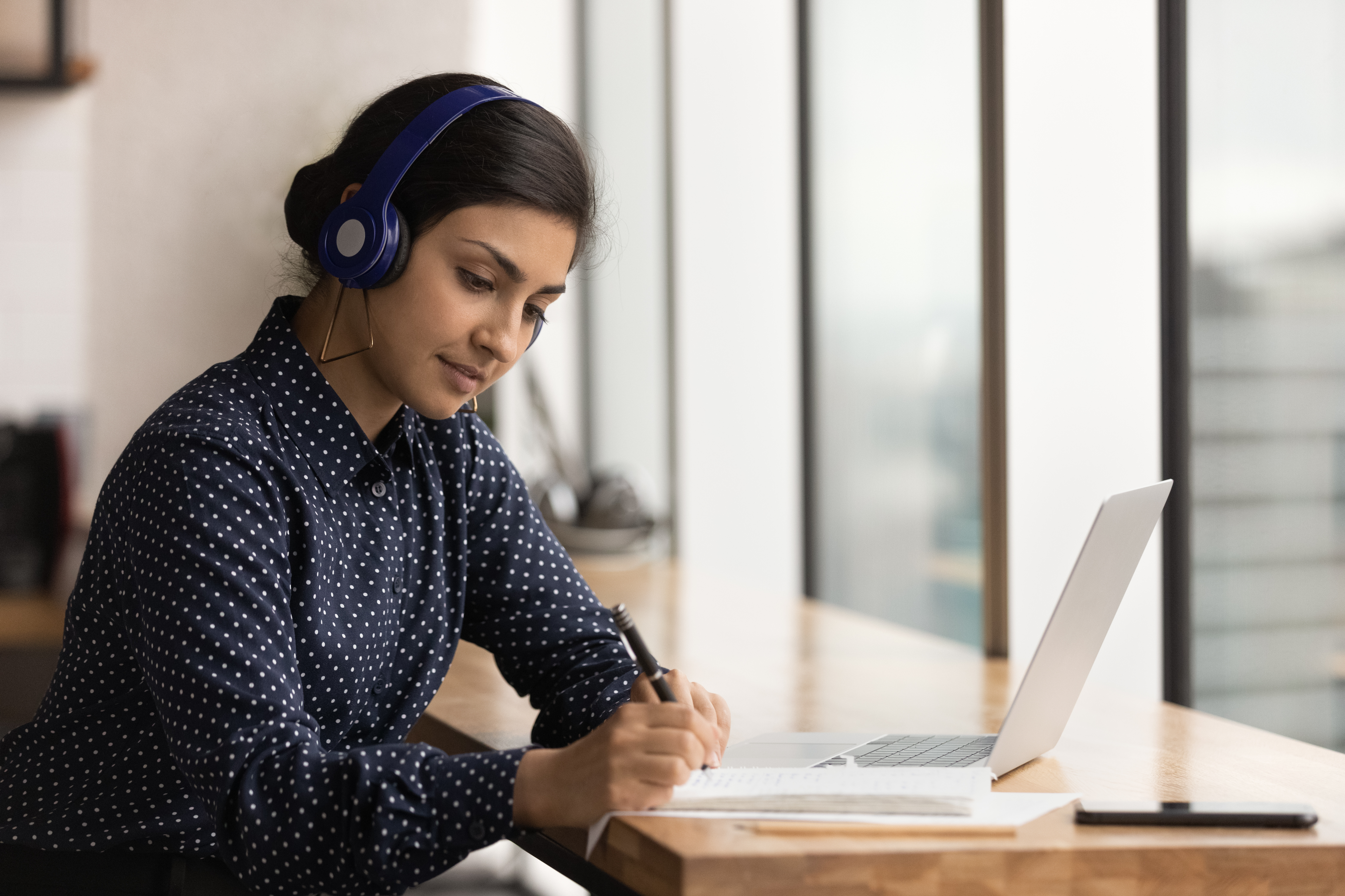 Attentive hindu woman trainee hearing lecture course online take notes