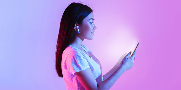 Photograph of a webcam on top of a monitor with orange and pink wall behind