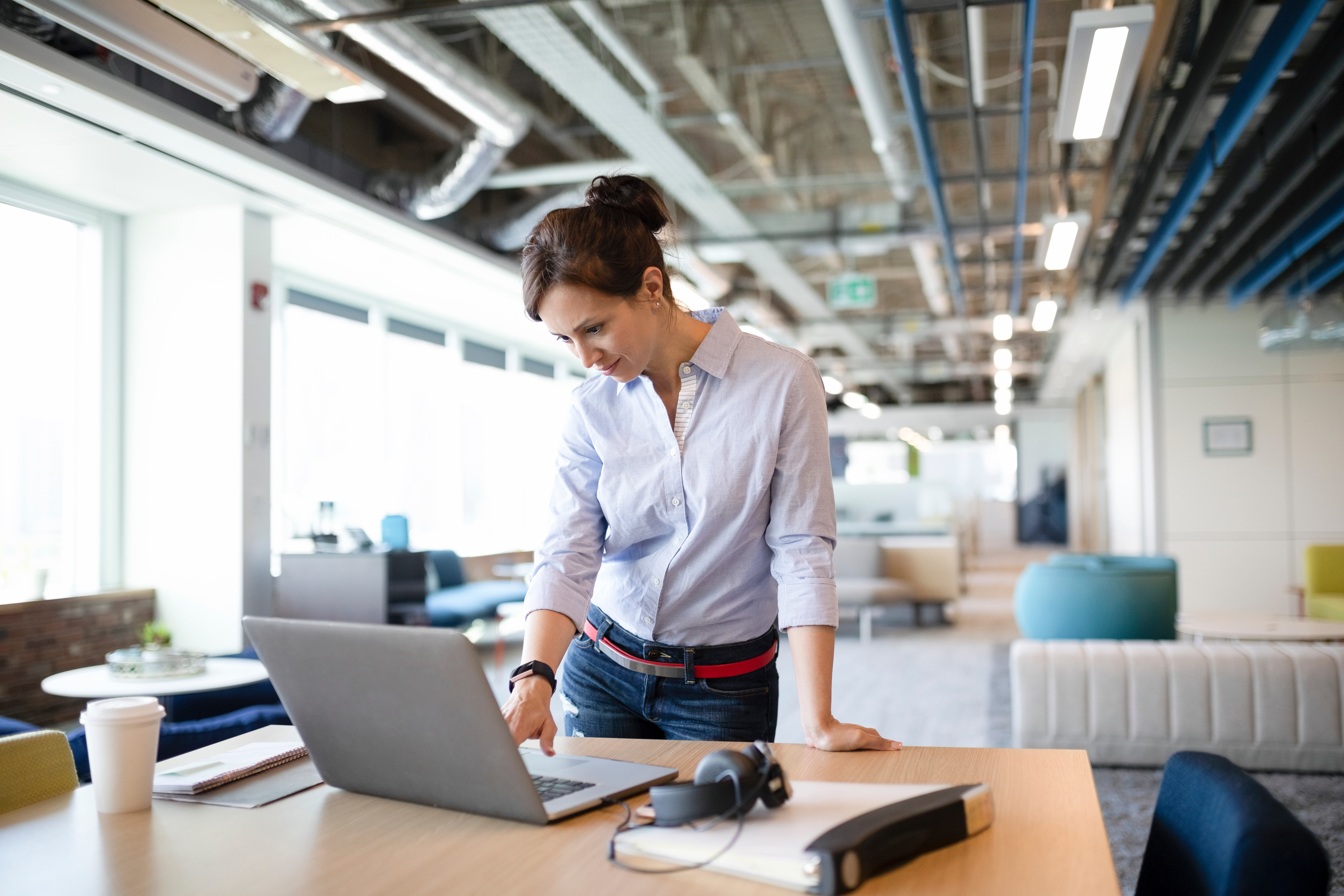 Businesswoman working at laptop in open plan office