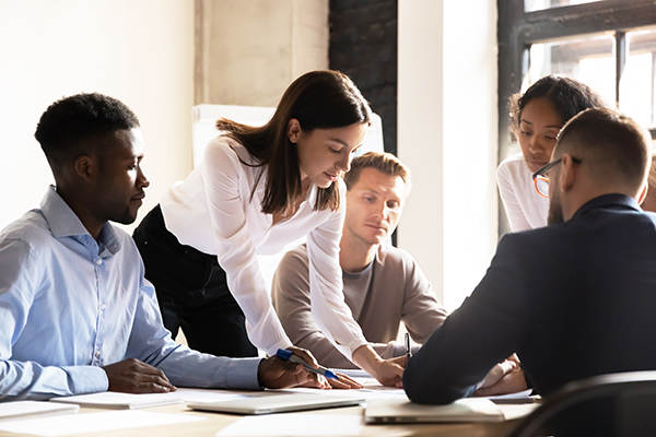 Diverse colleagues working on project together, sitting at table