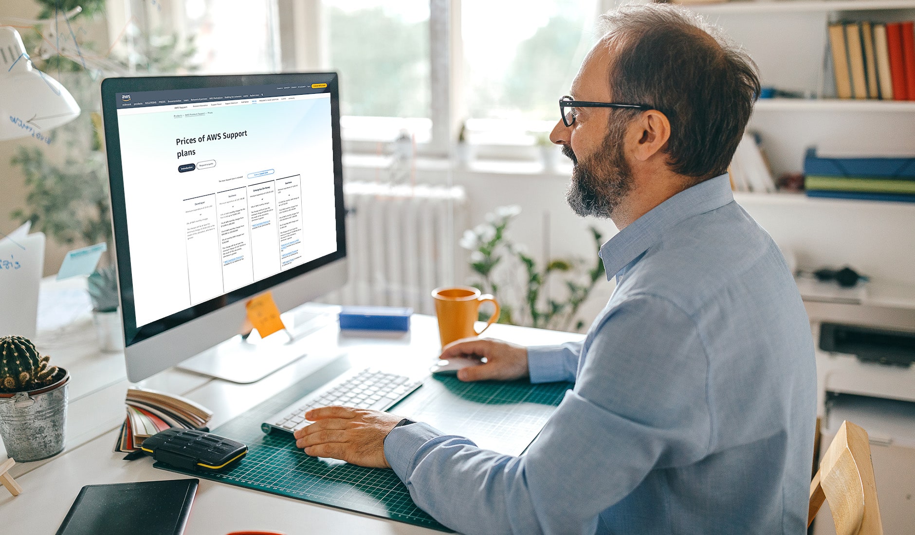 Man in a video call with co workers, reviewing the page 'Prices of AWS Support Plans'.