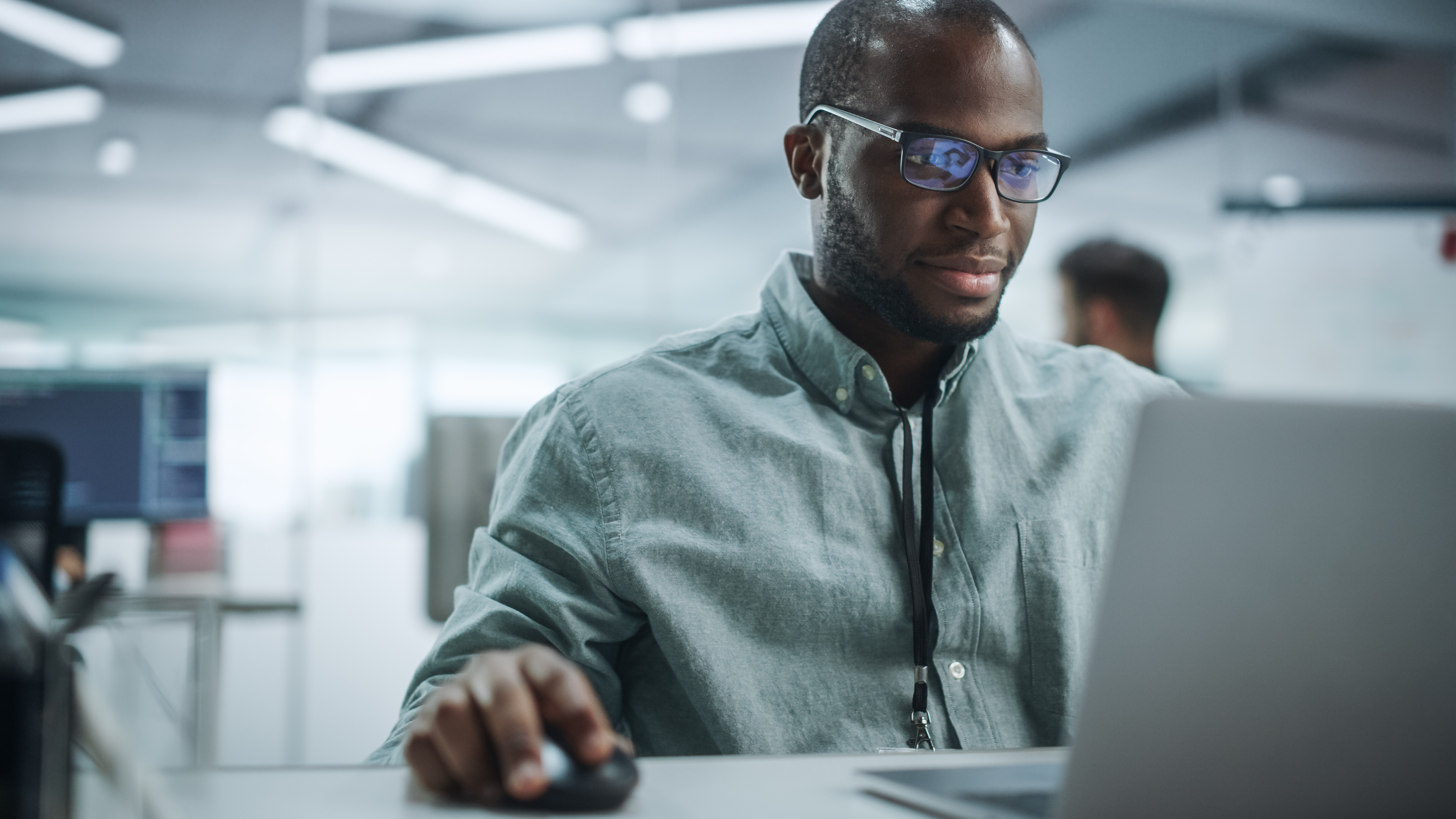 Modern Office: Portrait of Happy Black IT Programmer Working on Laptop Computer. Male Specialist Create Website, Software Engineer Develop App, Program, Video Game. Stress Free Inclusive Environment