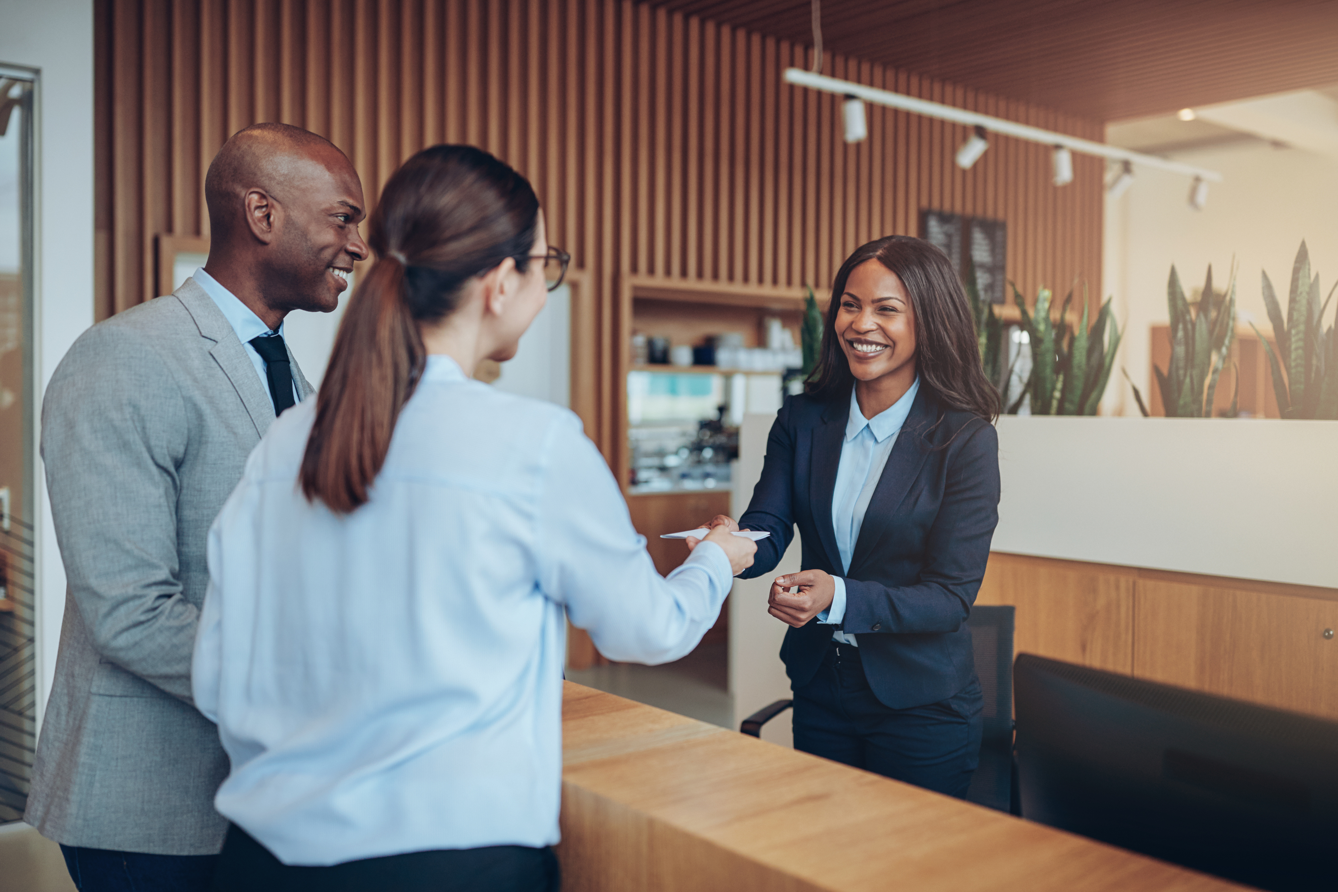 Smiling guests giving their check in information to hotel recept