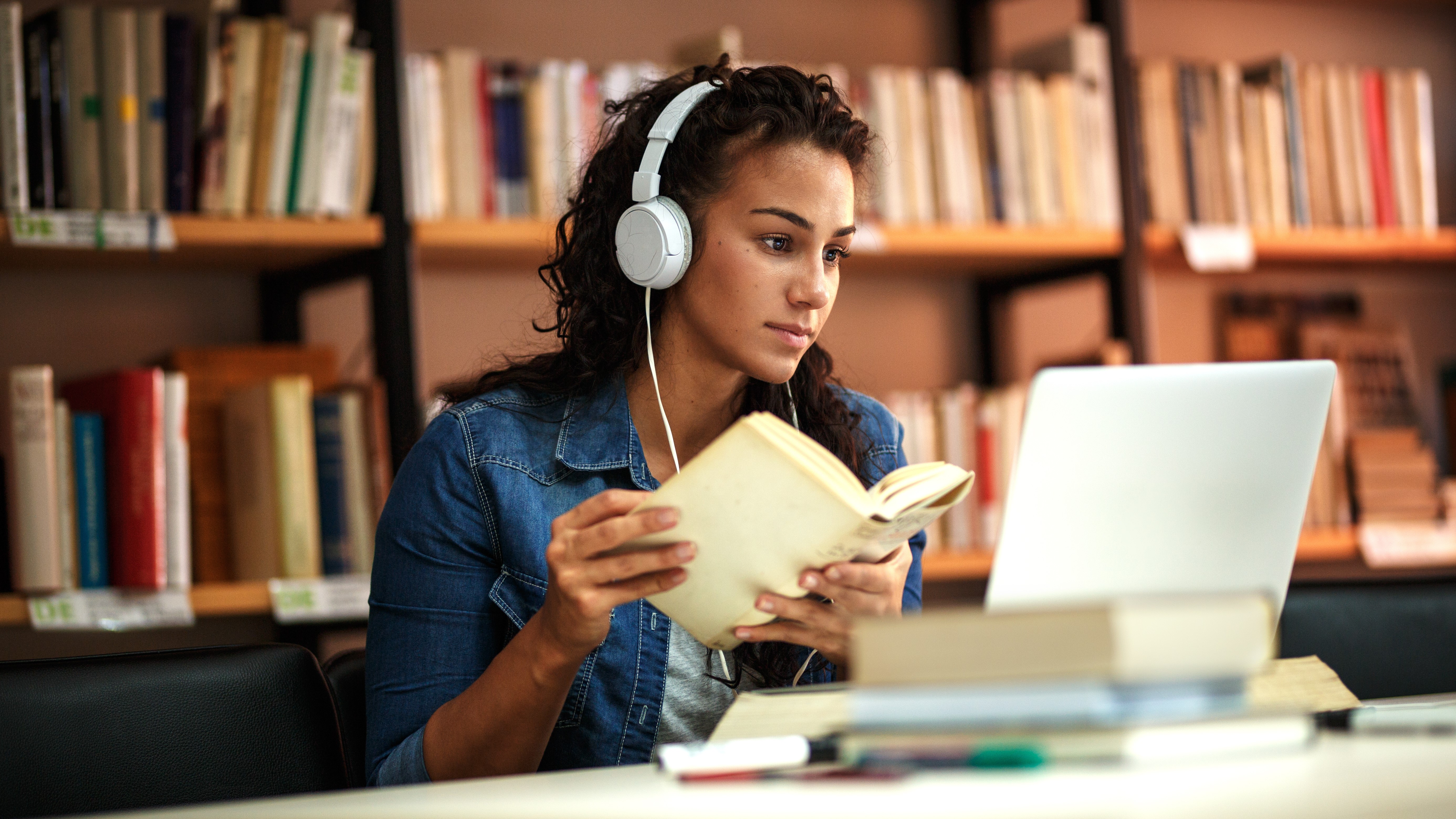 Estudante com livro e laptop