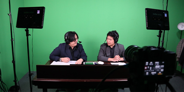 Filming two guys having discussion while seating in front of a green screen