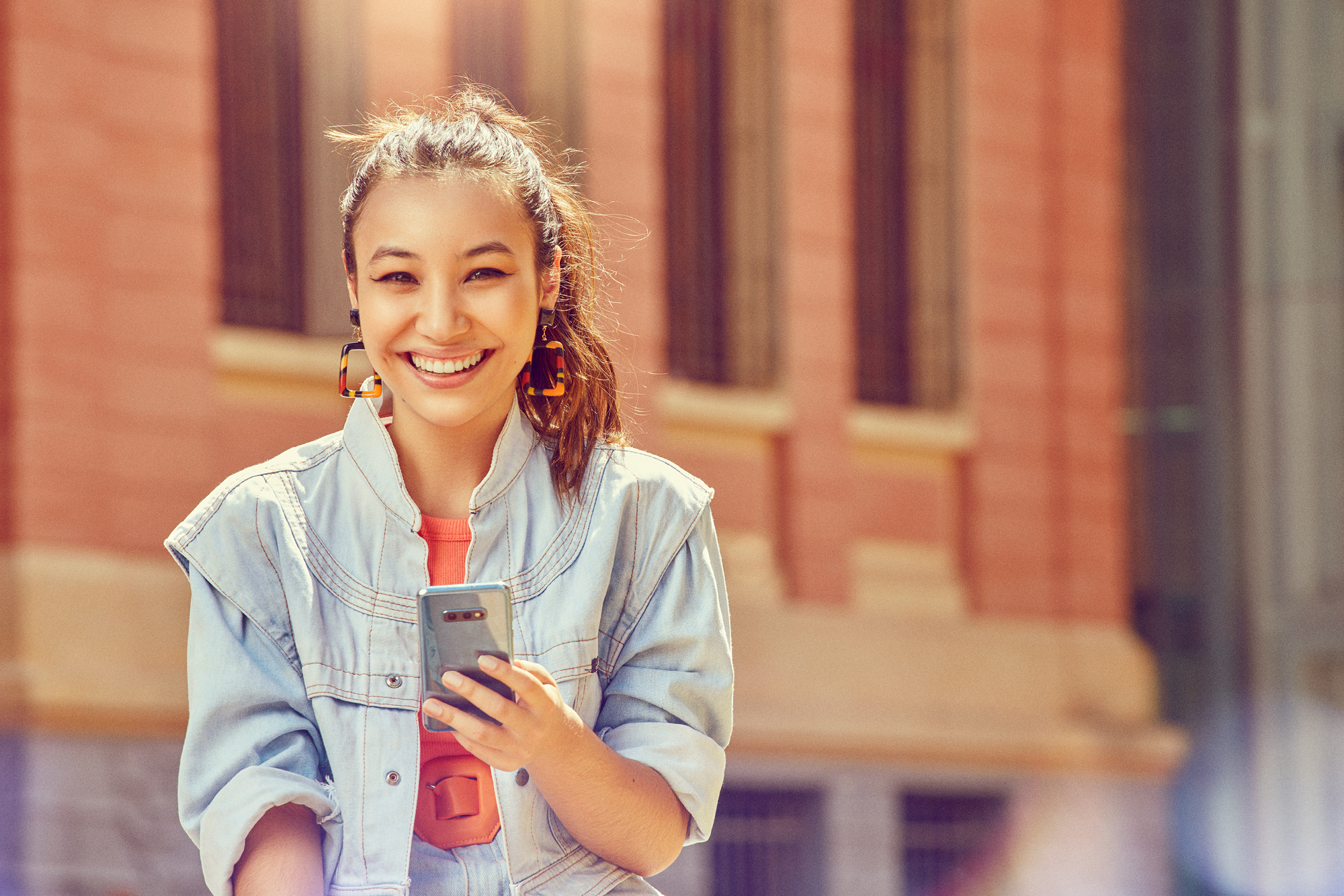 Young woman smiling while using app on smart phone 