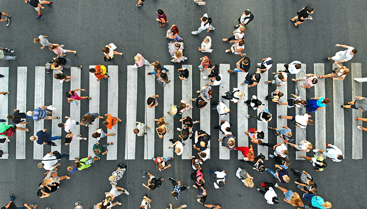 Aerial. People crowd on pedestrian crosswalk. Top view background.