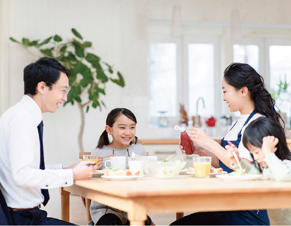 食卓で食事を囲む家族