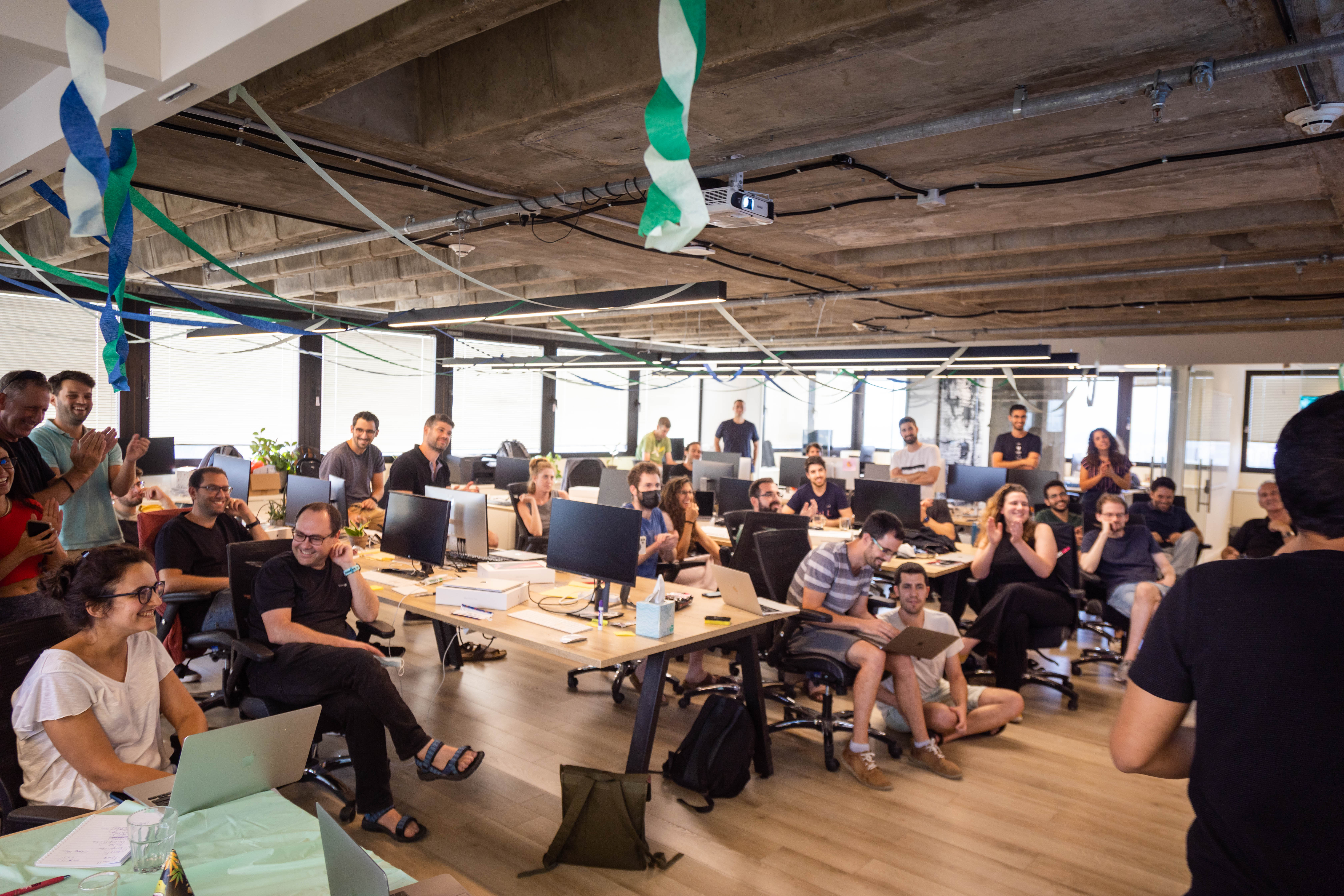 Members of the A121 team gather in their open office for a meeting