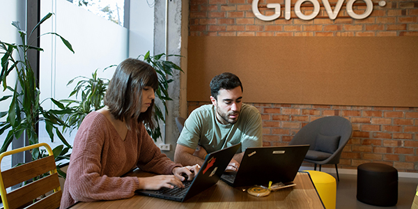 dois funcion&aacute;rios trabalhando em um escrit&oacute;rio da Glovo