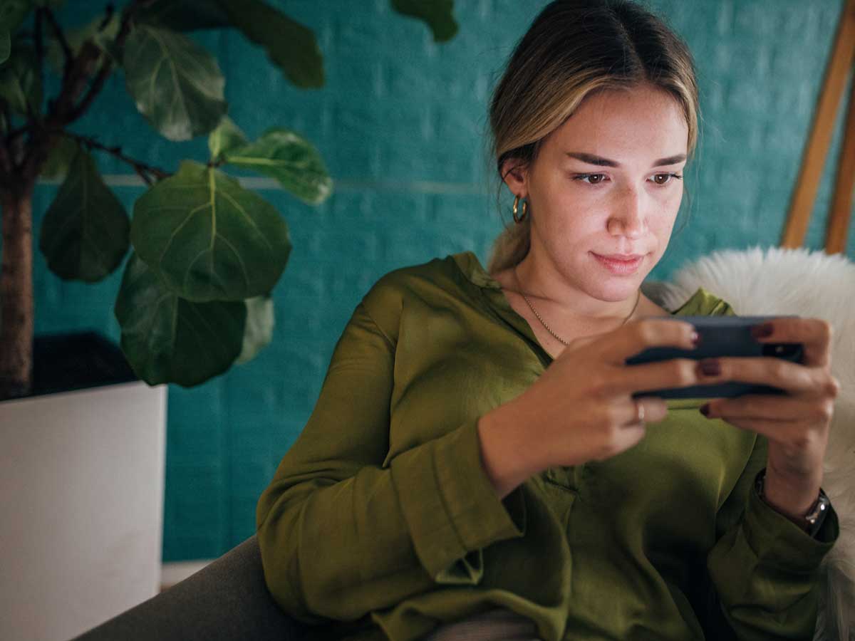 Frau hält mobiles Gerät in der Hand