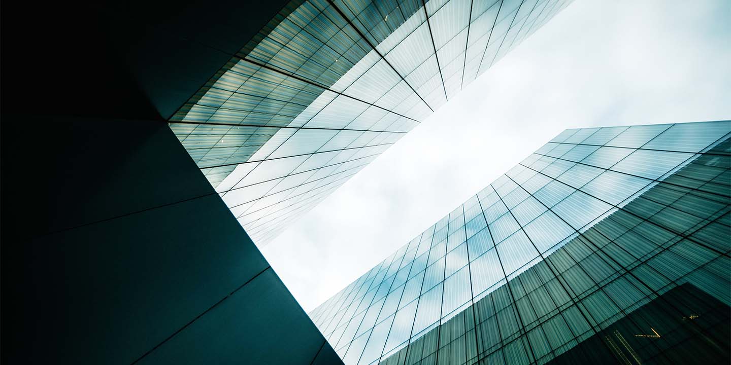 Standing at the base of two building looking skyward.