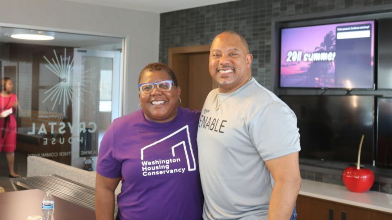 Two smiling Black Amazon executives, one man and one woman, pose together in an indoor setting at the ENABLE Summit event. 