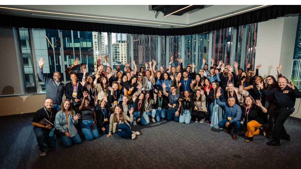 Image of a group of about 75 Amazon and AWS employees posing for a photo together in the Seattle corporate offices. The employees are some of Amazon's Global Inclusion Ambassadors.