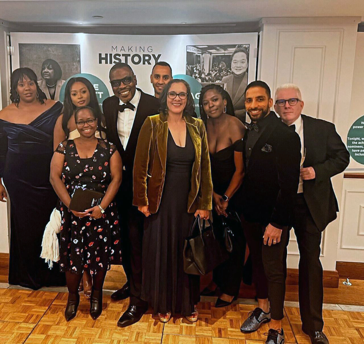 Members of AWS Global Inclusion Ambassadors pose together for a photo at a formal event. 