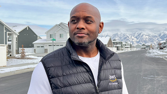 Chris Jackson, a Senior Startup Solutions Architect with AWS, wears an AWS vest in a snowy outdoor setting.