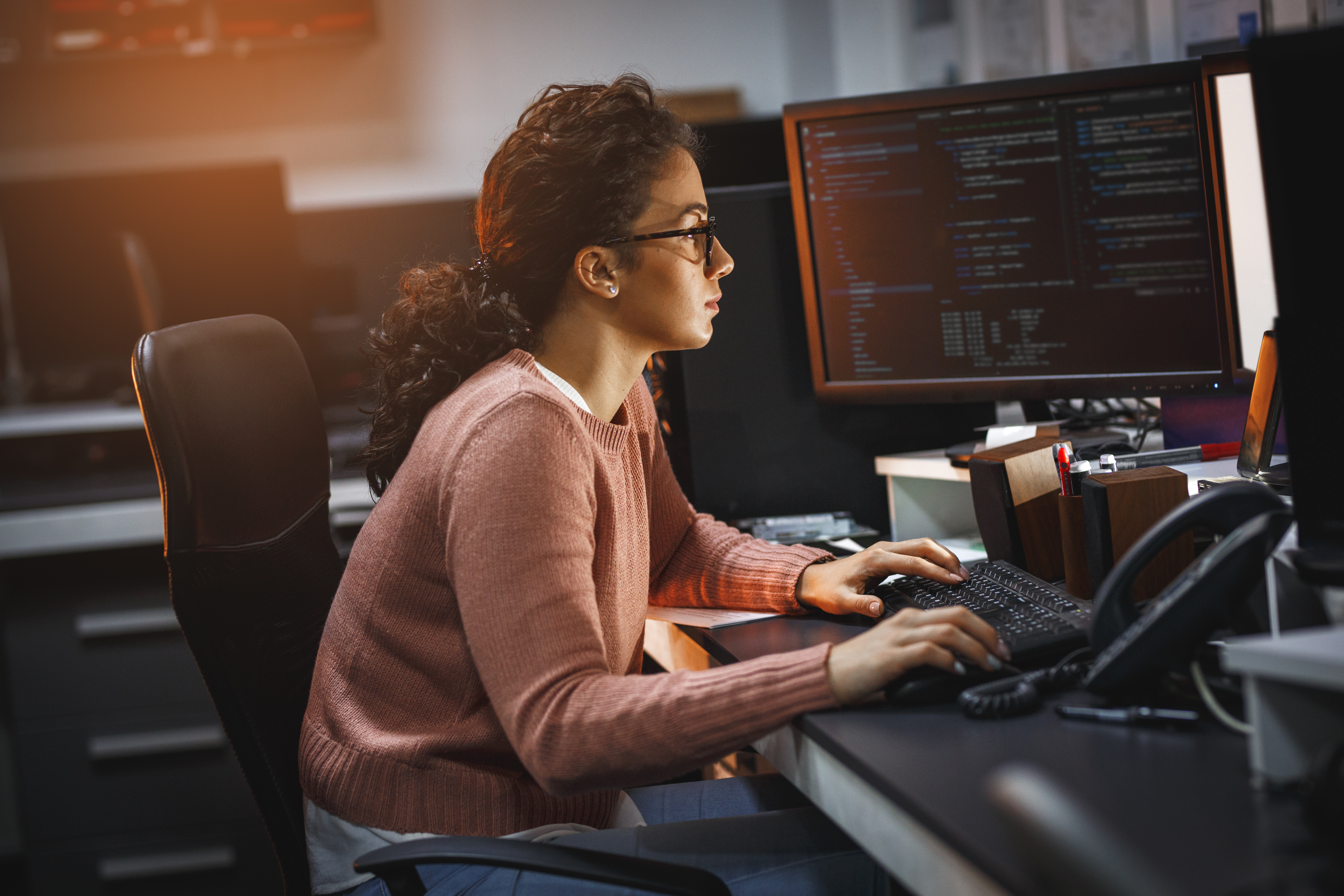 Female programmer working on new project.She working late at night in her office.