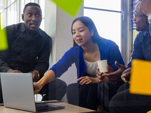 image representing Eliminating data blockers and team mates discussing info on a laptop