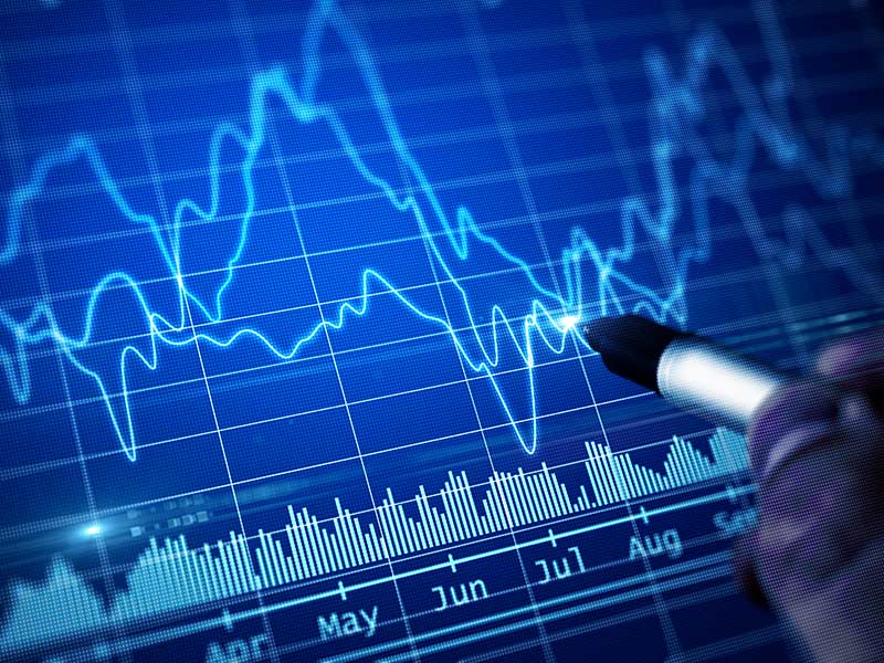 Hand with pen drawing financial chart. trading and investing concept