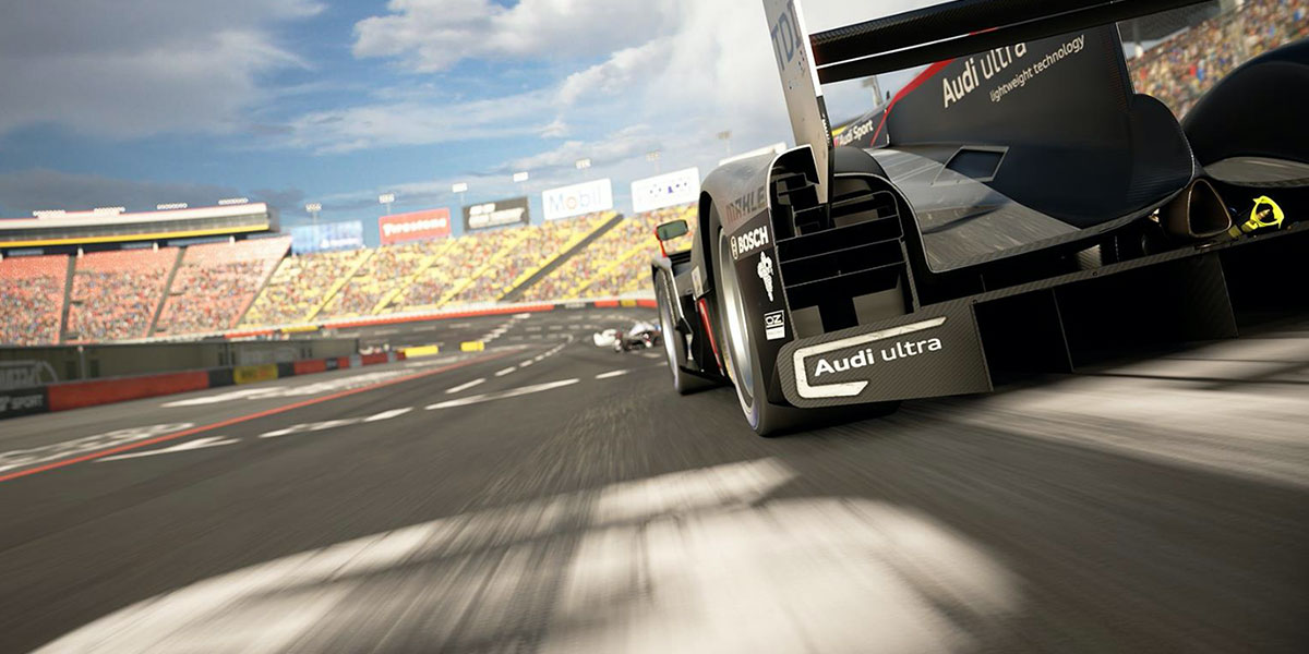 Still image showing the tail of a Audi race car driving around a track in a video game