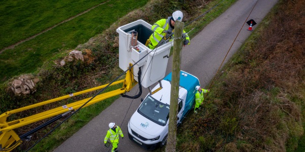 Power company worker attending to electricity pole