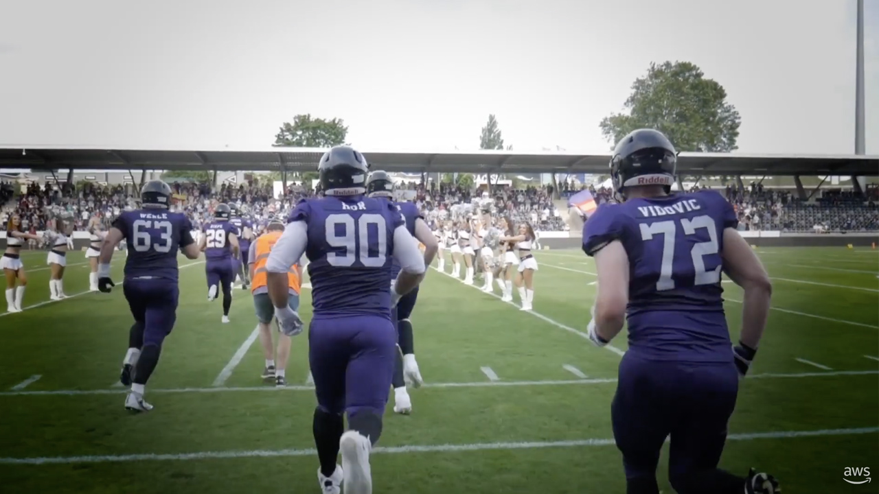 Football players wearing blue uniforms entering the field