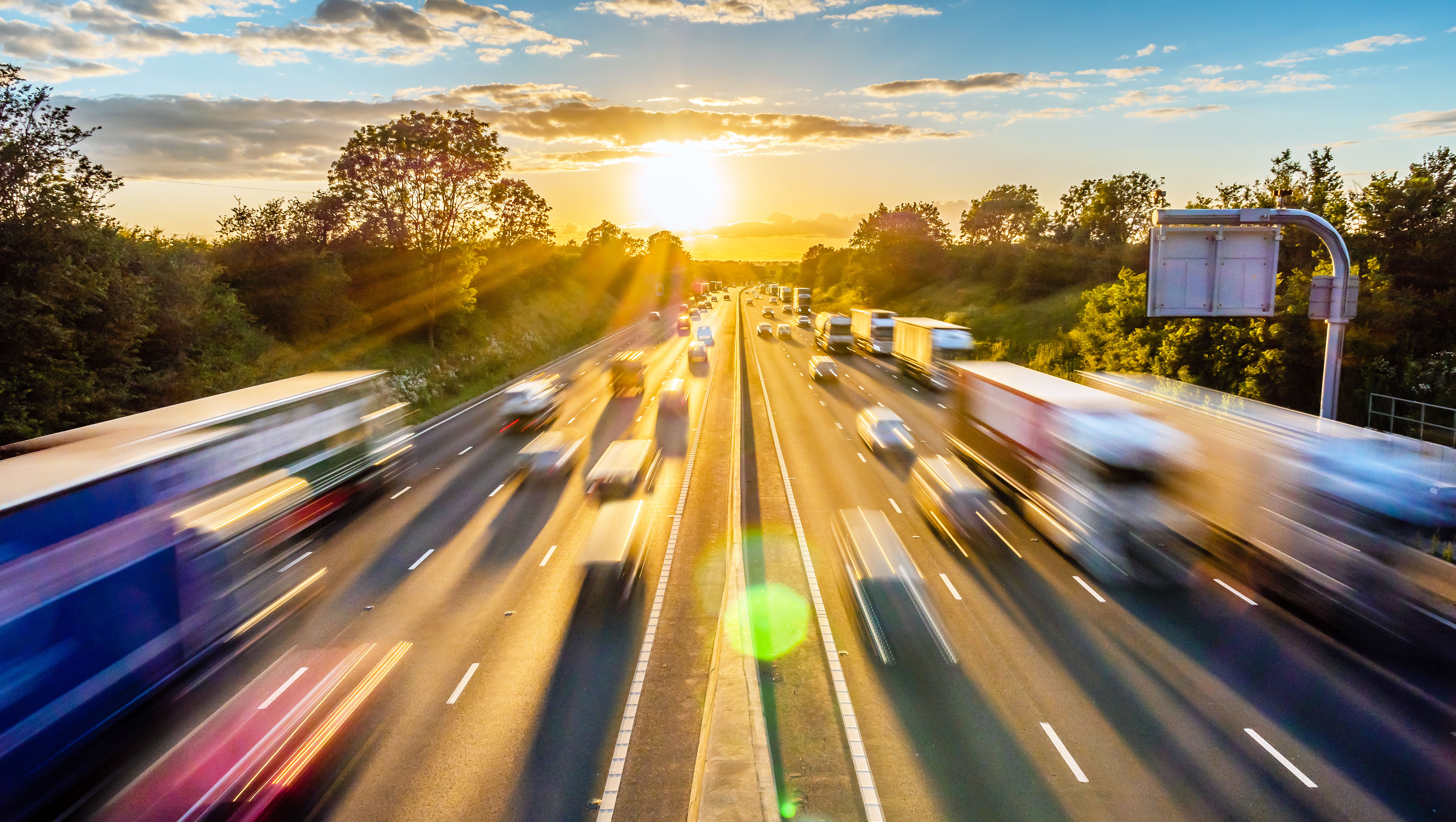 heavy traffic moving at speed on UK motorway in England at sunset