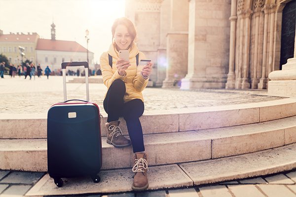 woman with suitcase and smartphone in hand