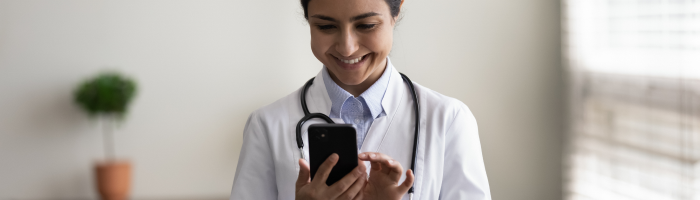 physician happily looking at cell phone