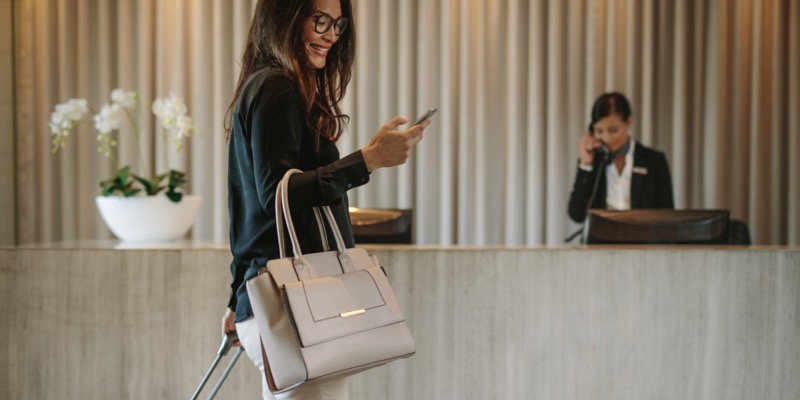 Business traveler in hotel hallway with phone 