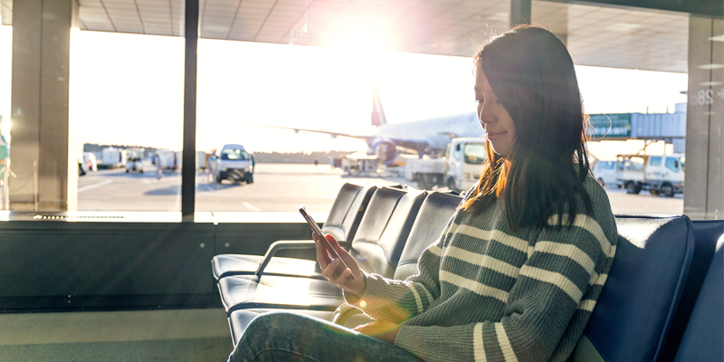 Femme r&eacute;servant un voyage au terminal de l'a&eacute;roport