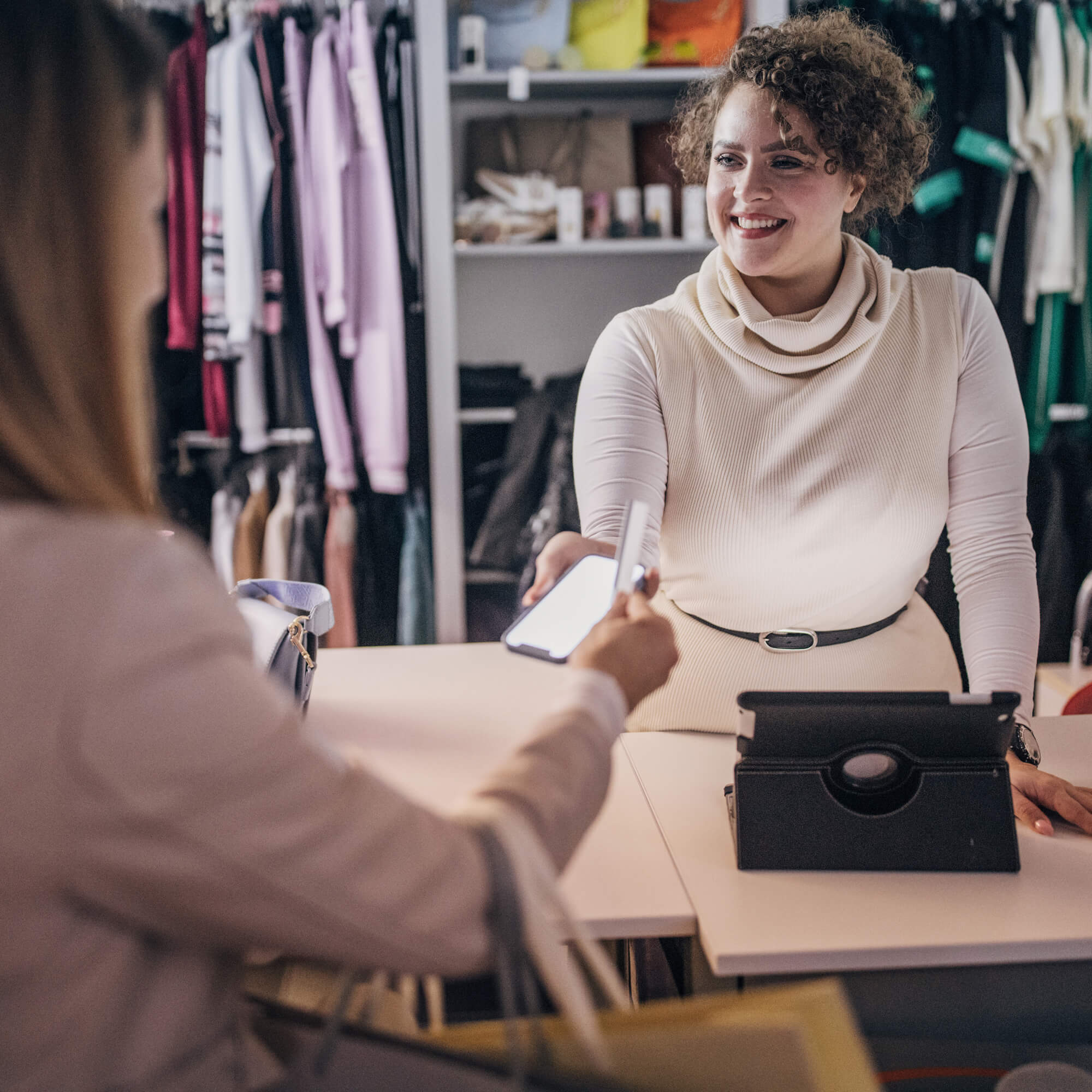 woman shopping for clothes paying at counter