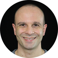 Portrait of a smiling person with a bald head on a black background