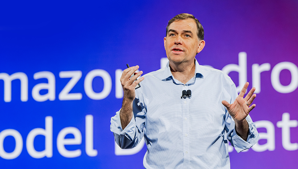Headshot of Matt Garman, CEO of Amazon Web Services, wearing a dark suit and tie and smiling.
