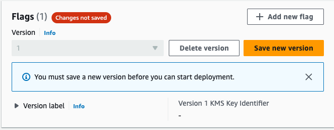 Screenshot of the AWS console 'Flags' section showing a warning message that changes are not saved, with a prompt to save a new version before starting deployment. The screen includes buttons for deleting or saving a new version, and an option to add a new flag.