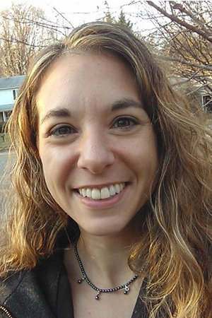 Portrait of a woman with long wavy hair smiling outdoors, representing an author for the AWS Builders Library.