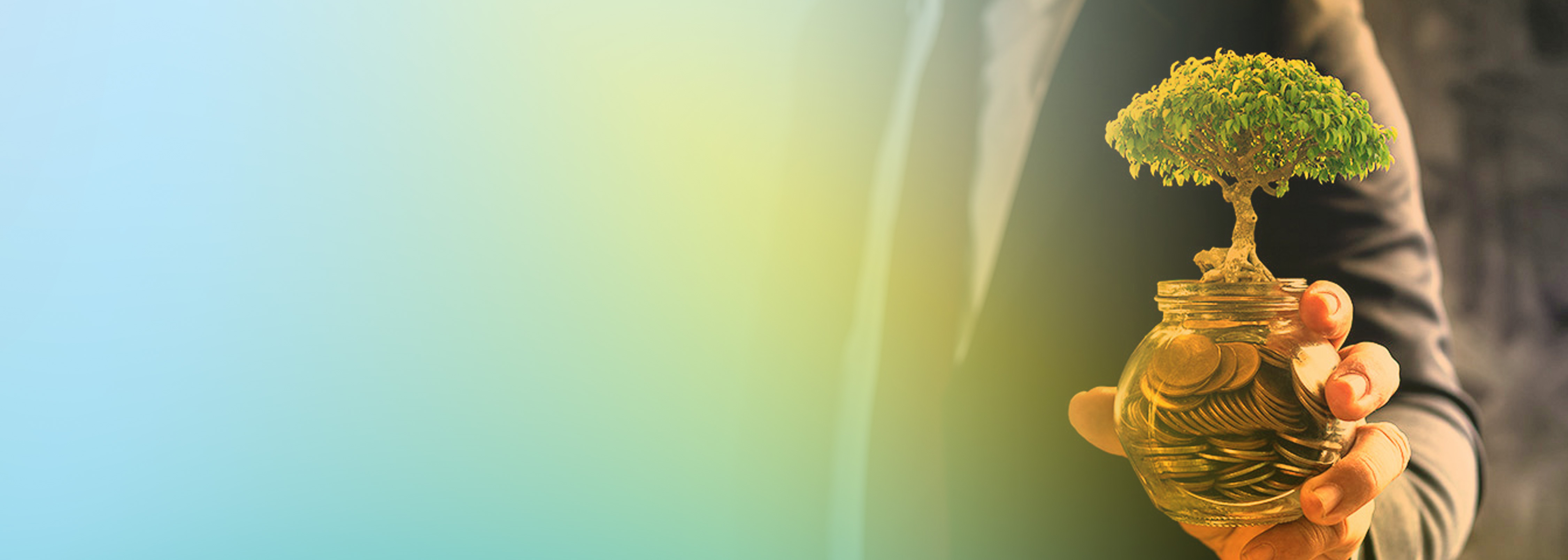 A person in a suit holding a glass jar filled with coins and a small tree growing from the jar, representing investment in sustainability and growth.