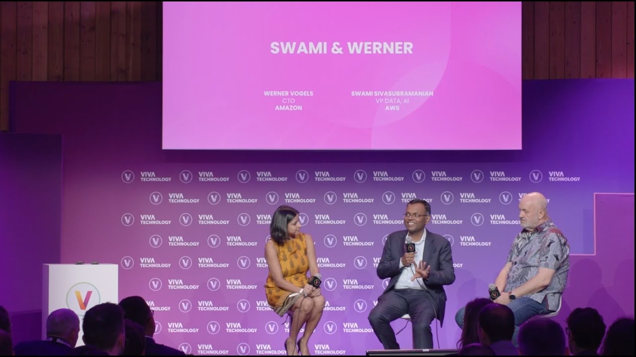 Panel discussion at Viva Technology 2023 featuring Swami and Werner, with three individuals on stage engaging in conversation, set against a purple Viva Technology backdrop.