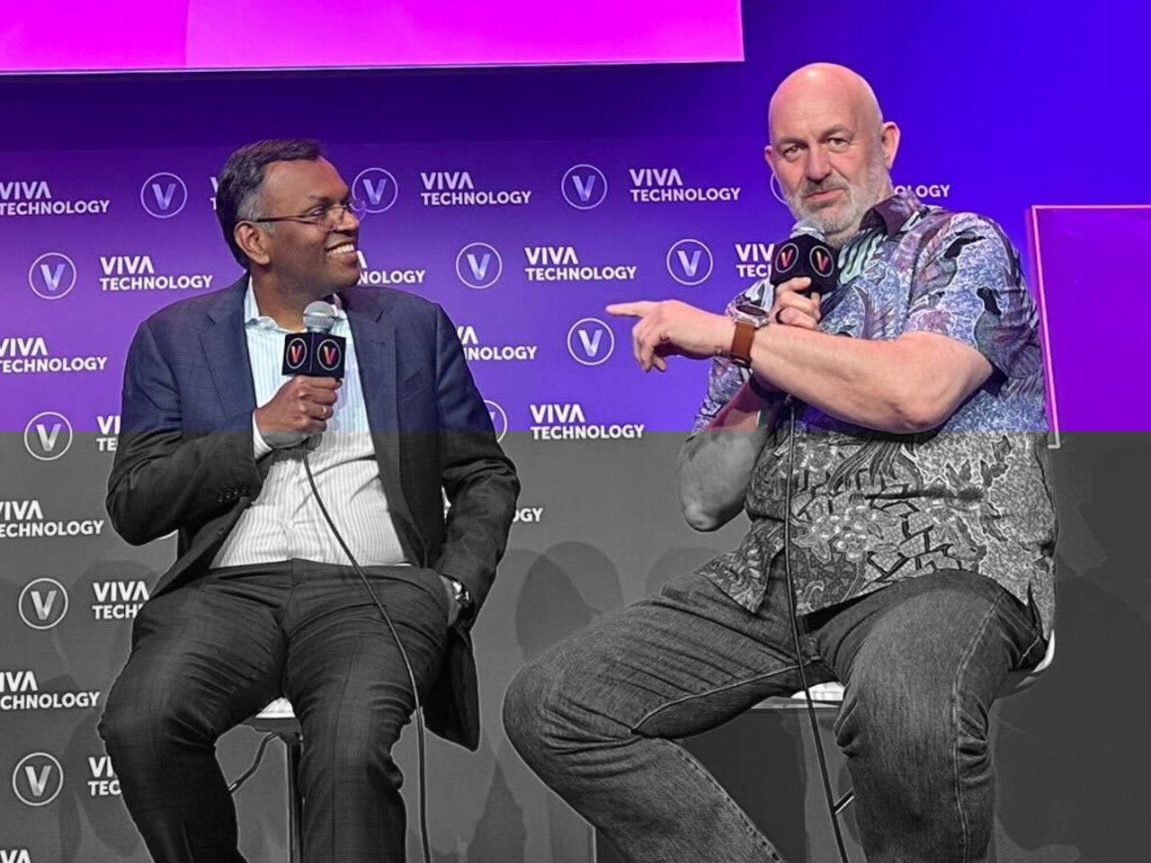Two speakers having a discussion on stage at VivaTech 2024 in Paris, sitting in front of a background that reads 'Viva Technology'. Both are holding microphones and engaging with each other during the event.