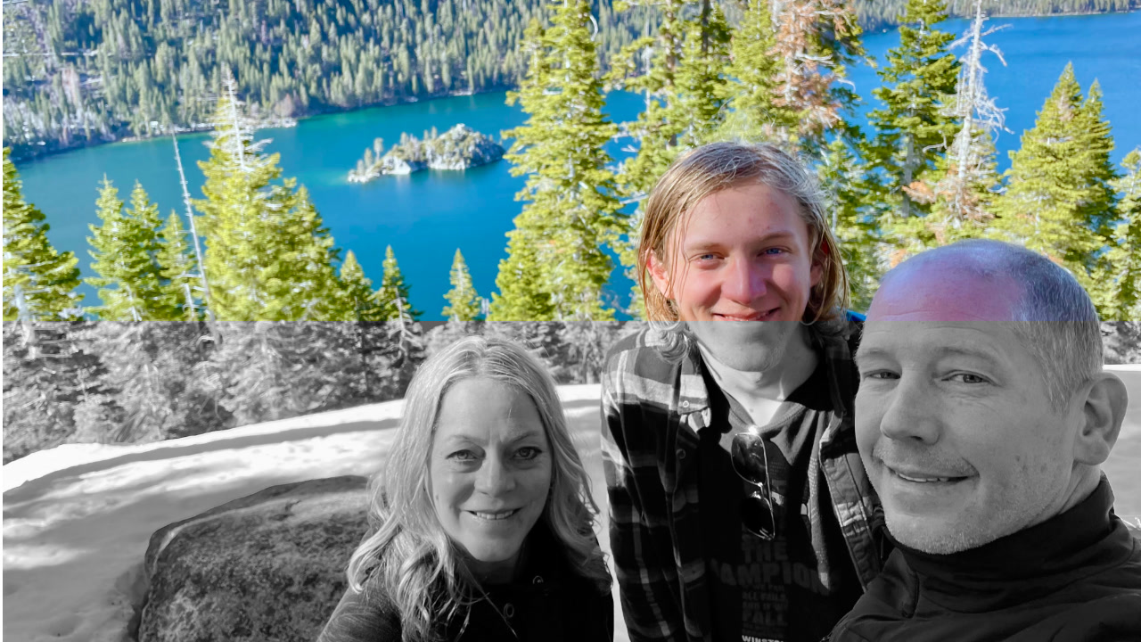 A family enjoying the outdoors with a scenic view of Lake Tahoe, surrounded by fir trees and blue water.