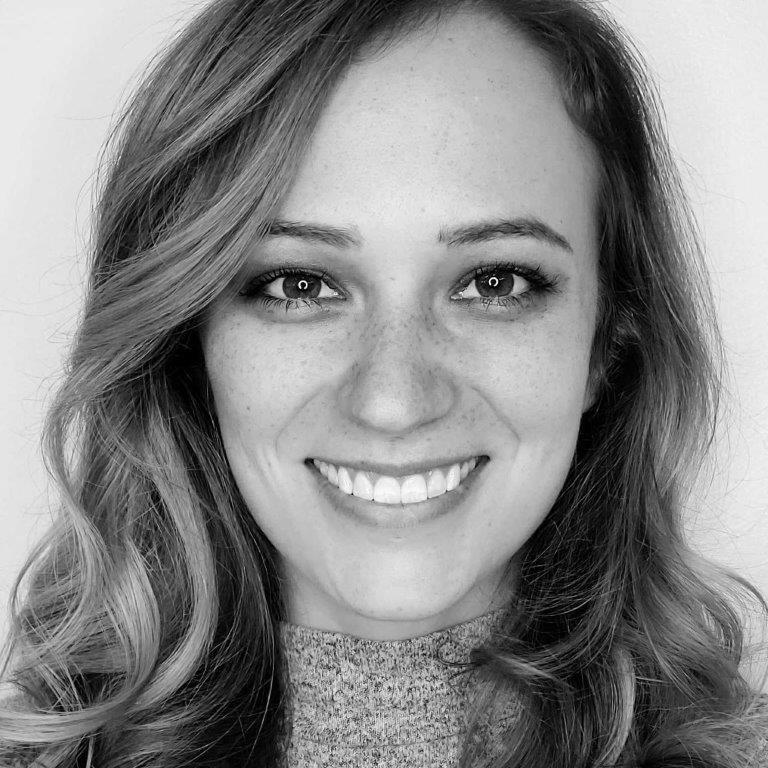 Wavy hair cascading over shoulders, with a textured sweater visible.