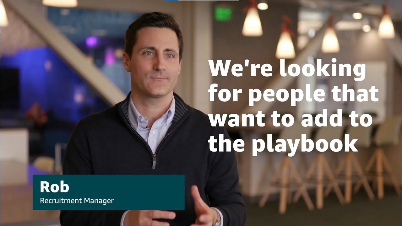 A YouTube thumbnail image featuring a person in a professional office setting with the text 'We're looking for people that want to add to the playbook' and a title card that reads 'Rob, Recruitment Manager'.