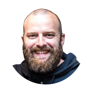 Profile image of a smiling person with a beard, wearing a dark hoodie, on a transparent background. Used for AI and machine learning expert profile.