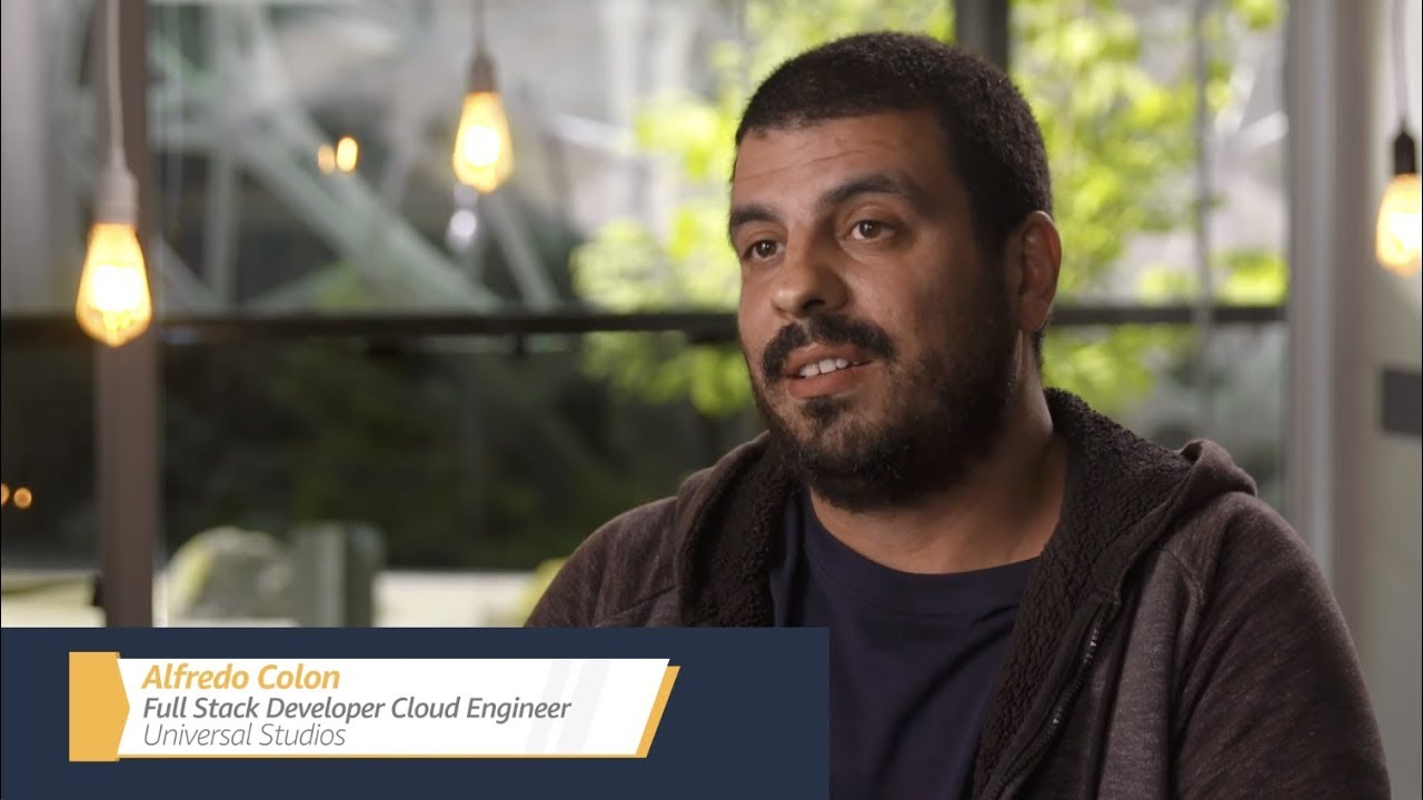 YouTube thumbnail featuring Alfredo Colon, Full Stack Developer Cloud Engineer at Universal Studios, in an interview setting with hanging lights and a bright background.