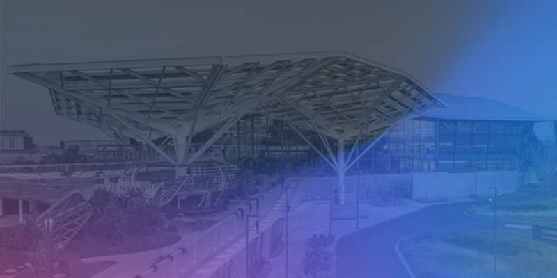A view of the NVIDIA campus featuring modern architectural design with a purple and blue gradient overlay.