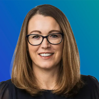 A person with shoulder-length brown hair wearing a dark top, set against a blue gradient background.