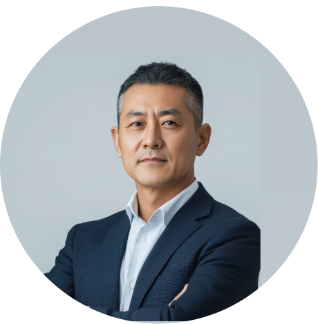 A professional headshot of a businessman in a suit with arms crossed, posing confidently in front of a neutral background.