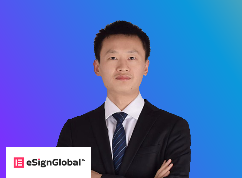 A business professional in a suit and tie stands confidently in front of a blue gradient background. The eSignGlobal logo is visible in the bottom left corner, representing a professional or company branding image.