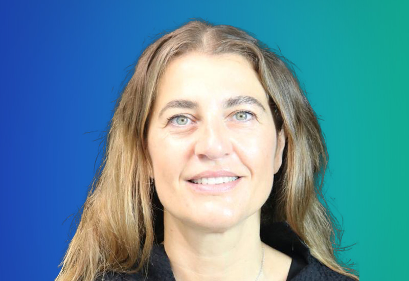 Professional headshot of a woman with long hair, smiling, in front of a blue and green gradient background. Used for Milano ExecLeaders event.